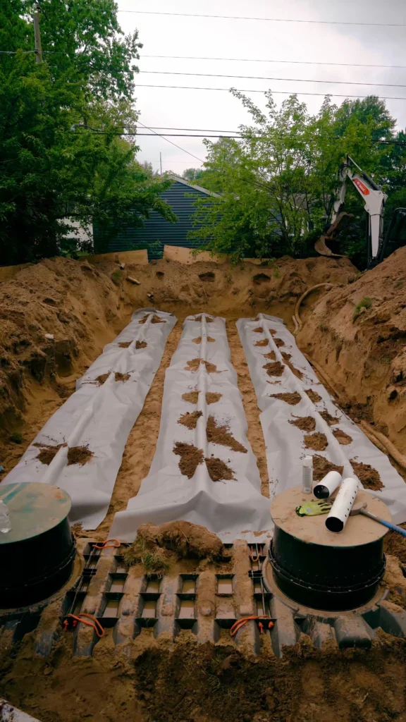 Construction trench with rows of white plastic-wrapped conduits laid in the dirt, awaiting installation for underground utilities. - arwwm - arwwm