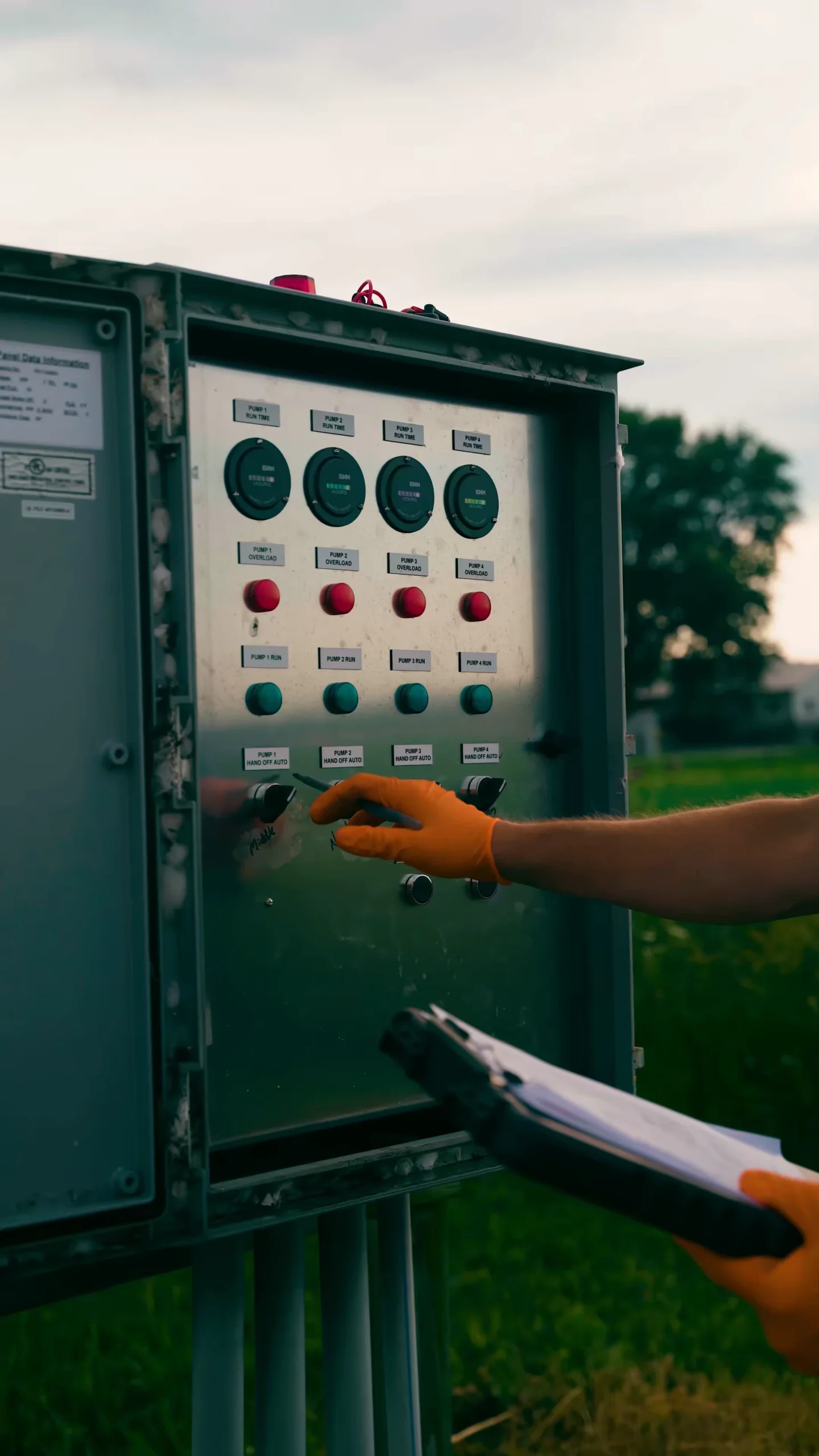 Electrical Checks On Septic 3 - ARWWM - ARWWM Outdoor industrial control panel with green start buttons and red stop buttons; gloved hand operating a switch. - arwwm - arwwm