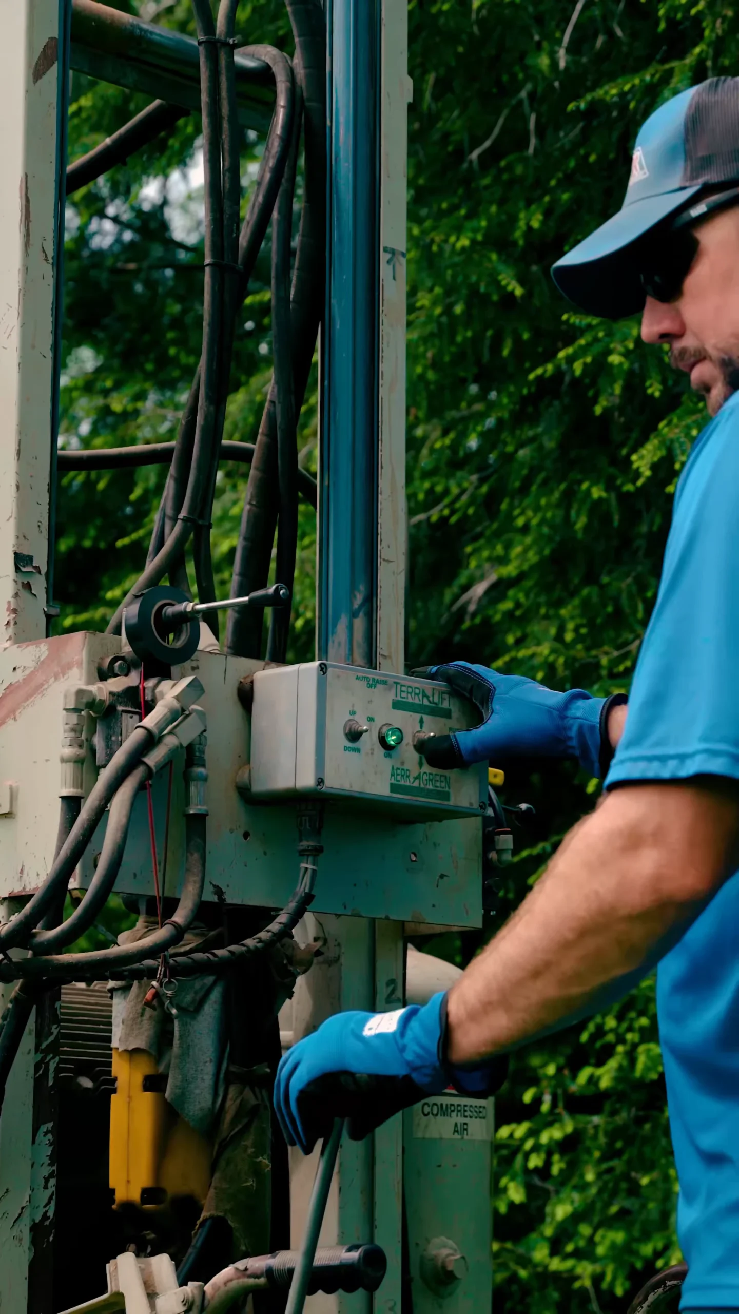 Terralifting - ARWWM - ARWWM Industrial worker in blue gloves operates a control panel on outdoor machinery with cables visible. - arwwm - arwwm